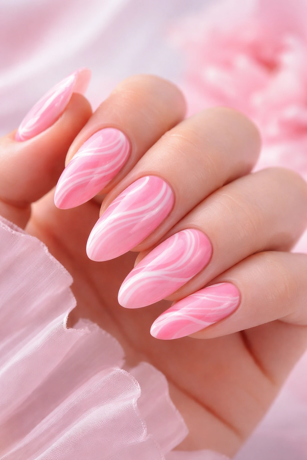 Close-up of pink swirl nails with flowing patterns in pink tones