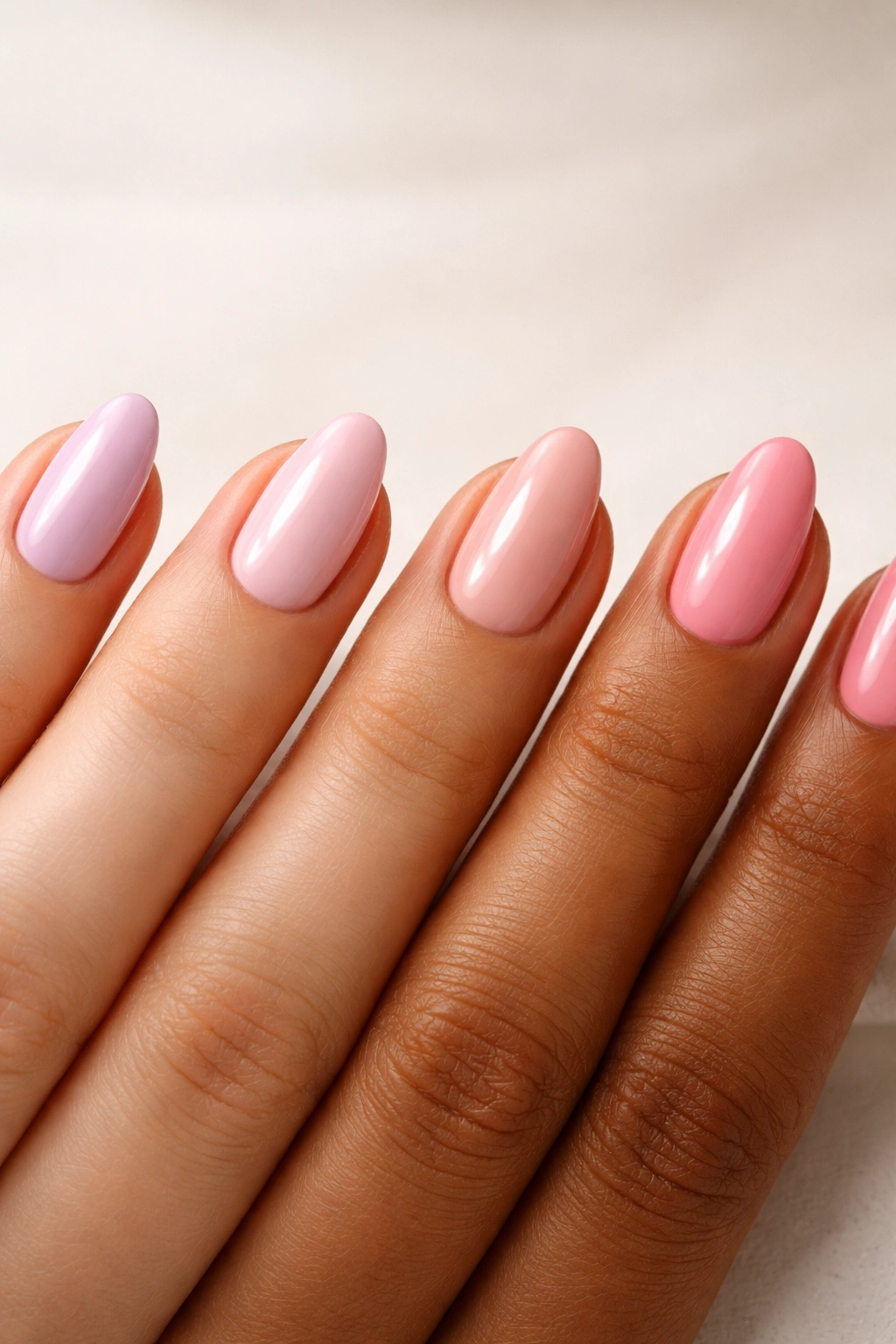 Close-up of four pink nail swatches on a neutral background representing cool, warm, and neutral undertones