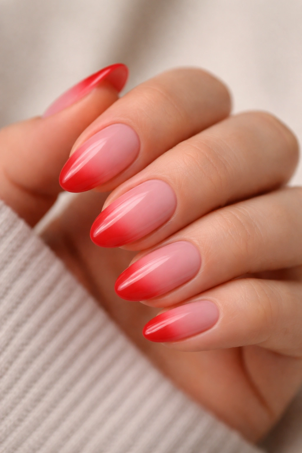Almond nails with pink to red ombre gradient on tips