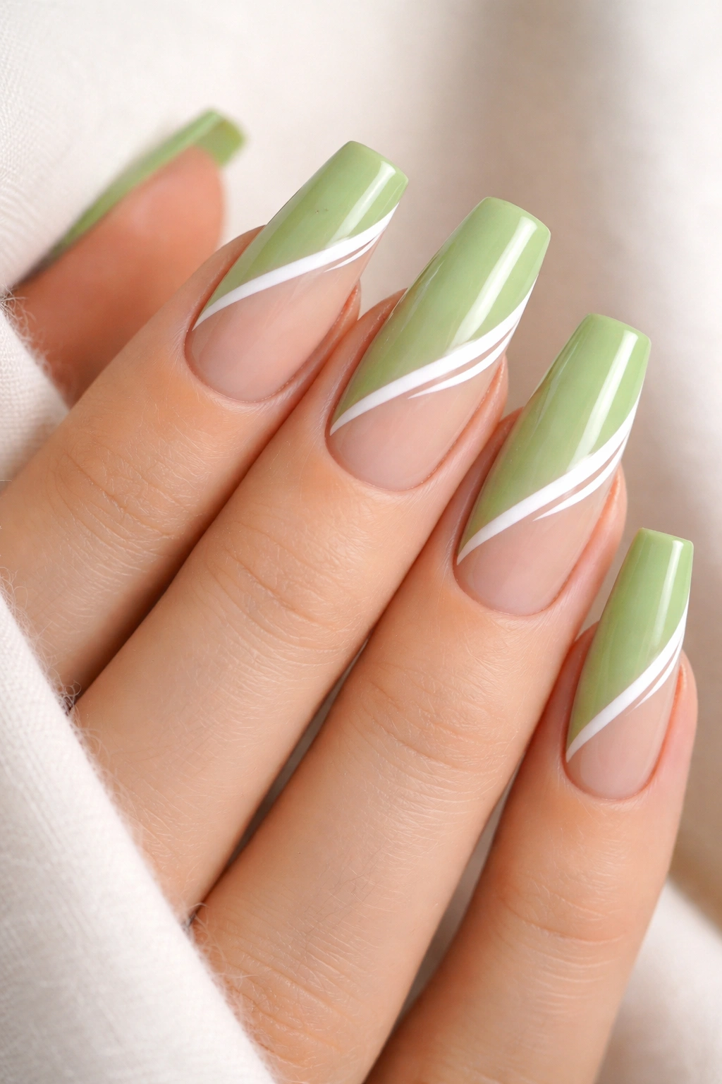 Pistachio green coffin nails with white stripes and negative space.