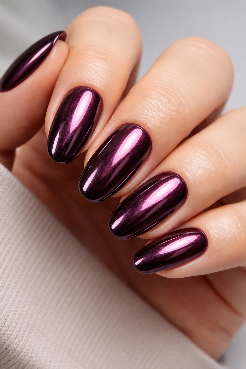 Close-up of Classic Plum Chrome manicure with deep plum nails and reflective chrome finish