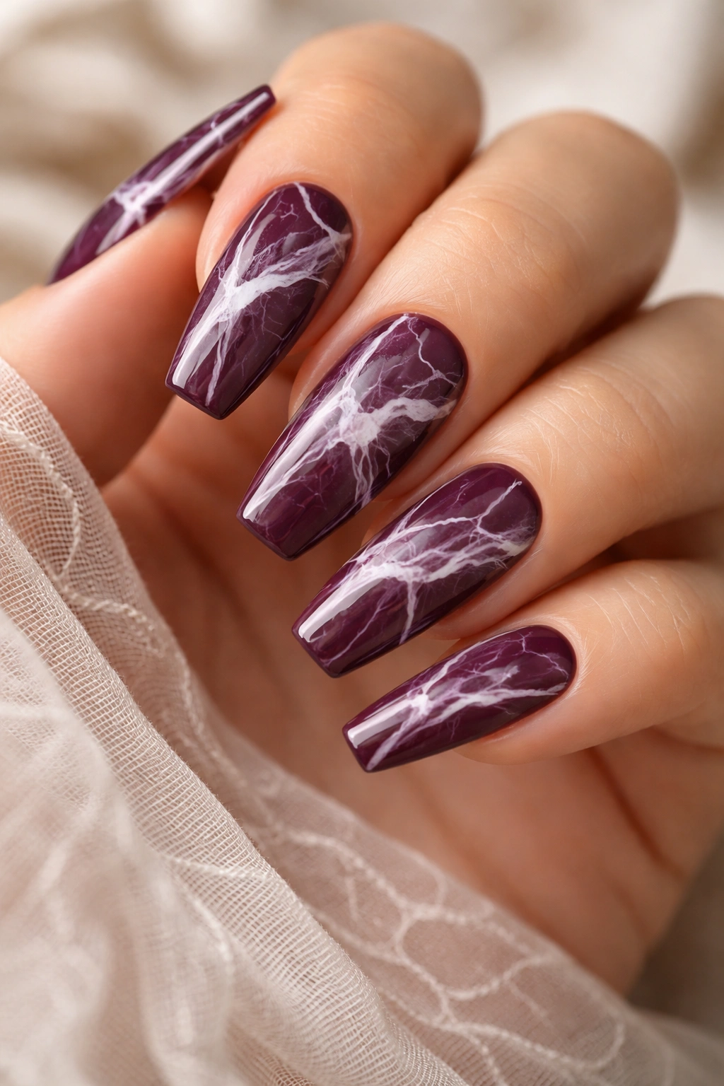 Plum coffin nails with white marble swirls on each nail