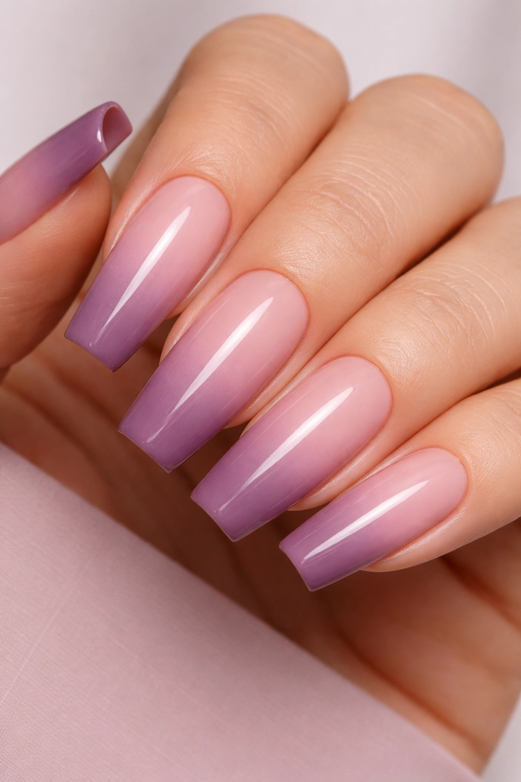 Close-up of long ballerina nails with a three-band plum-mauve gradient over dusty pink base