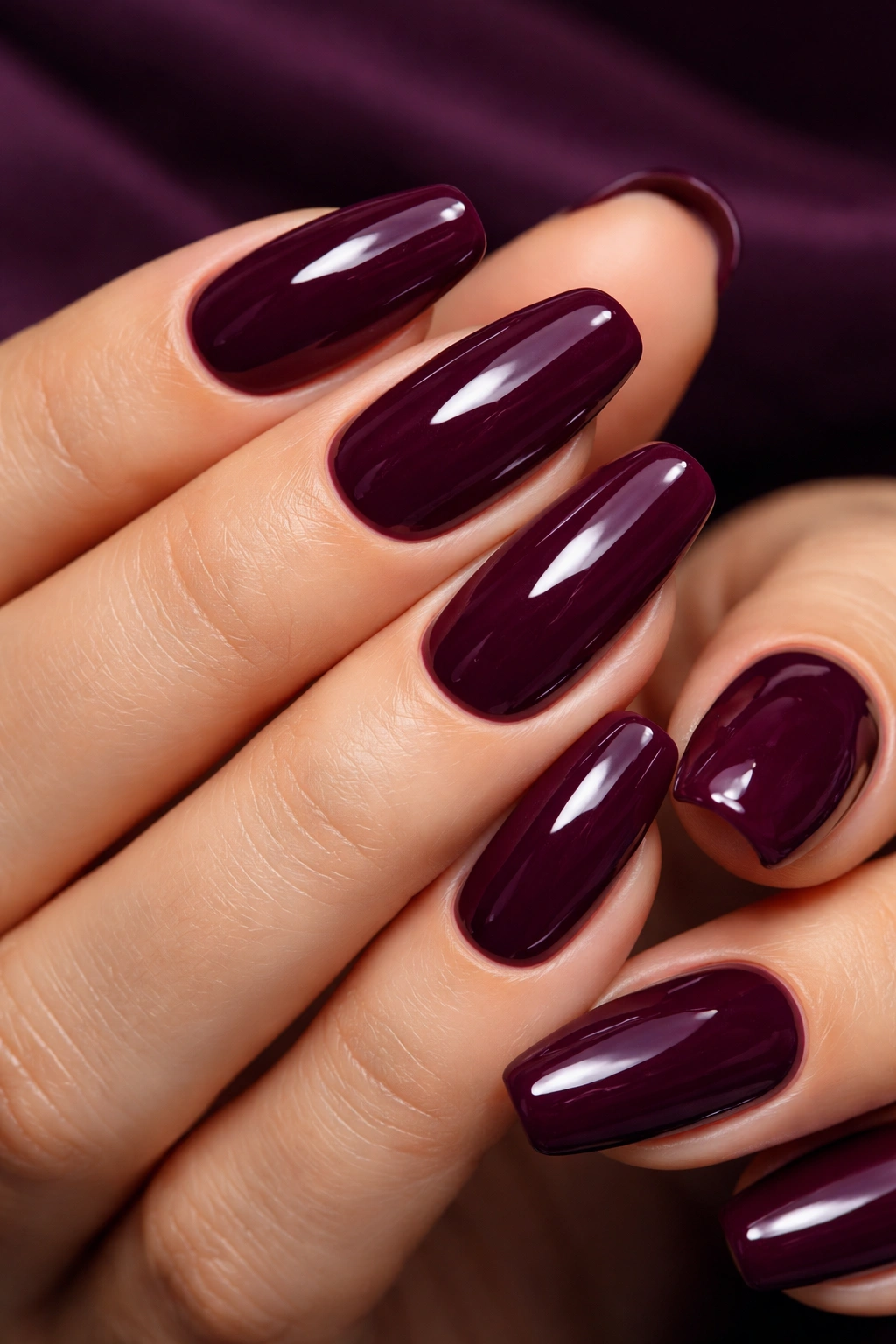 Close-up of deep plum dip powder nails on natural nails