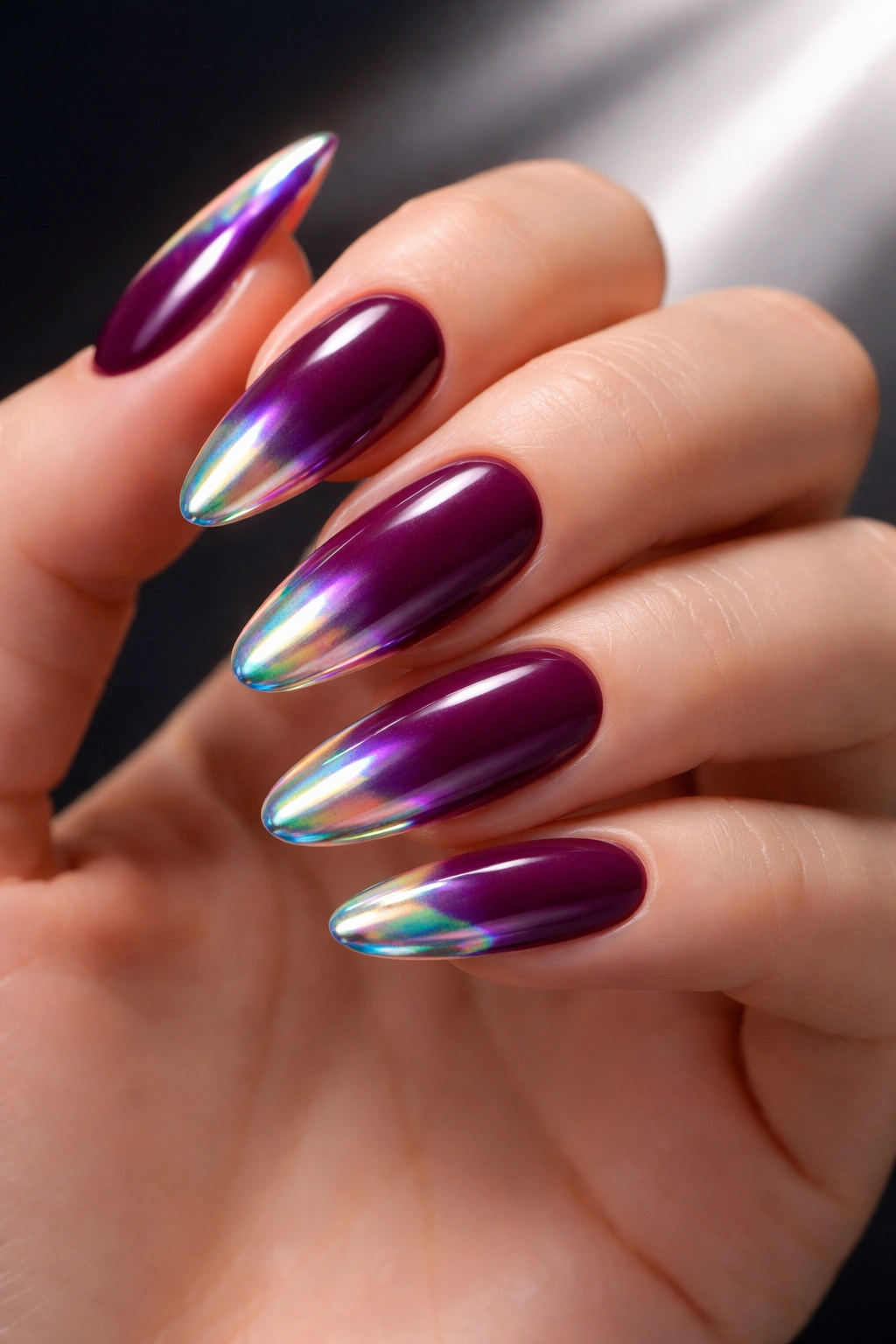 Close-up of plum nails with holographic chrome tips