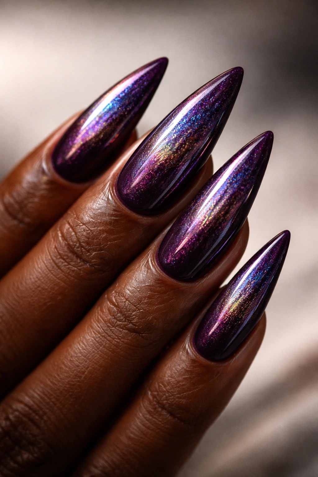 Deep plum stiletto nails with holographic shimmer