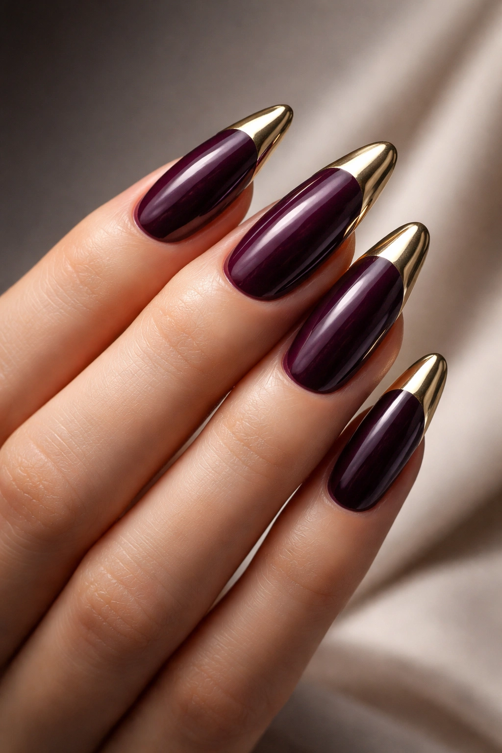 Long oval nails in rich plum with metallic tips