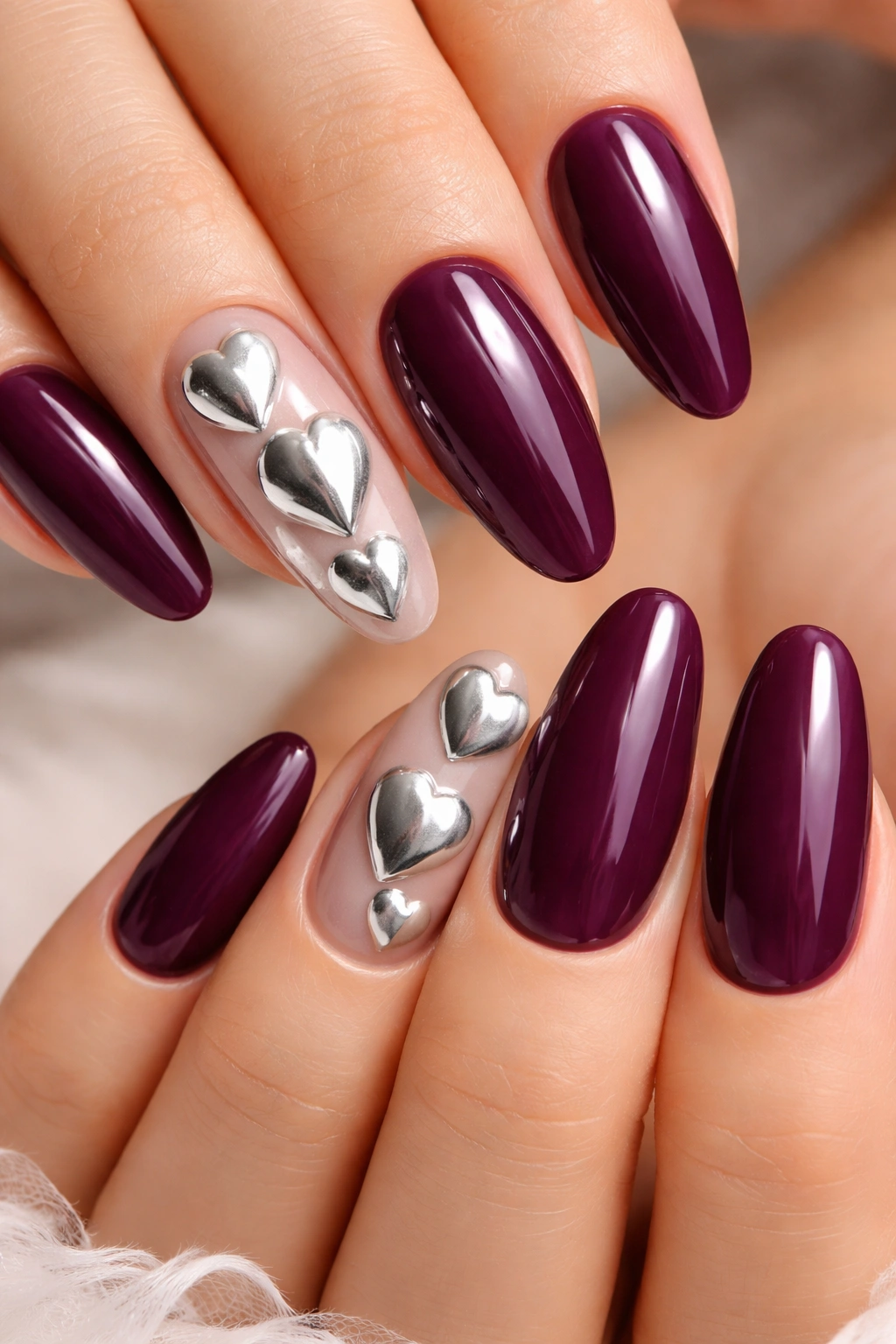 Close-up of deep plum nails with silver heart accents
