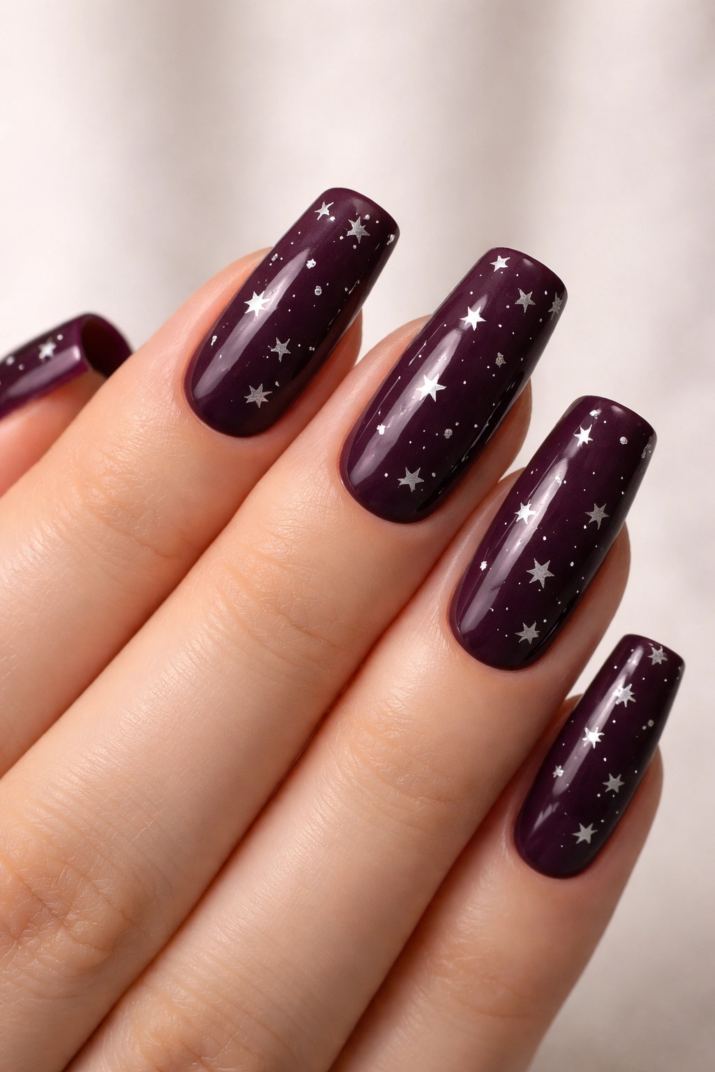 Deep plum nails with tiny star stamping