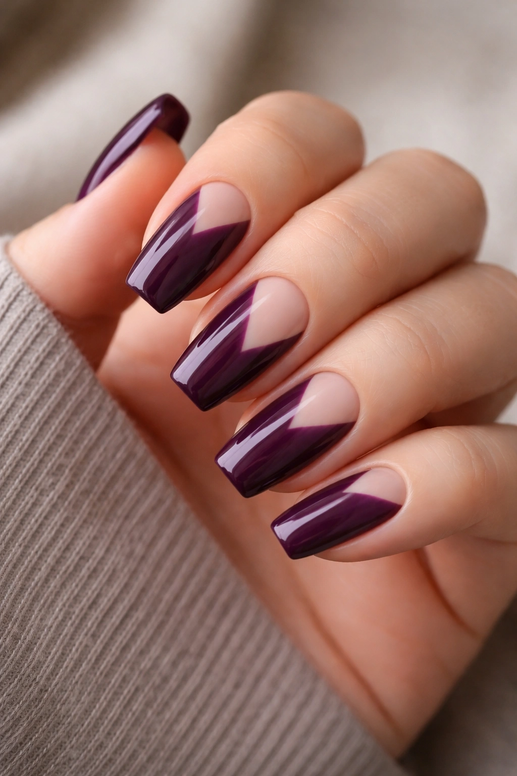 Close-up of plum coffin nails with negative space design on a hand