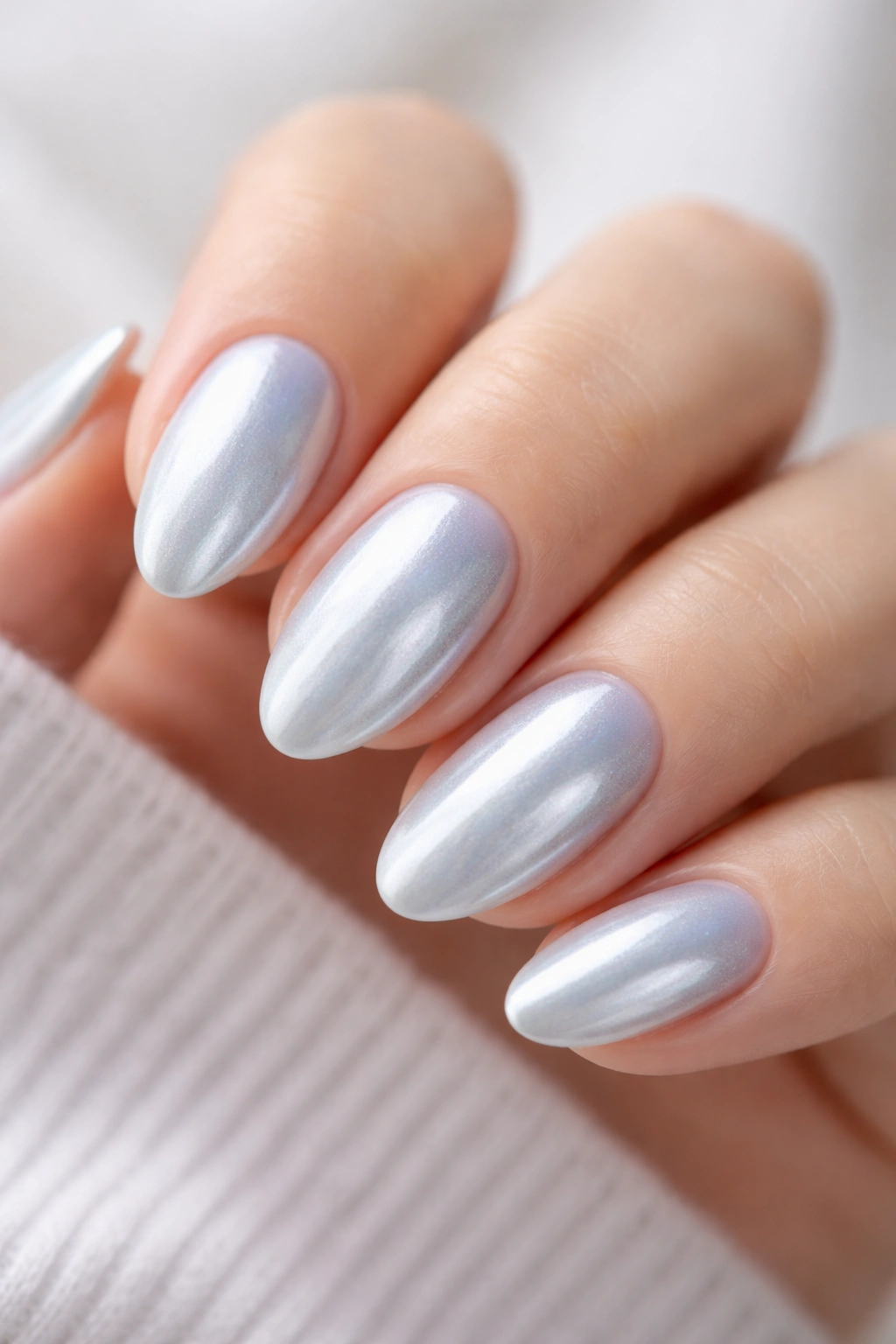 Close-up of short almond nails with powder blue chrome finish