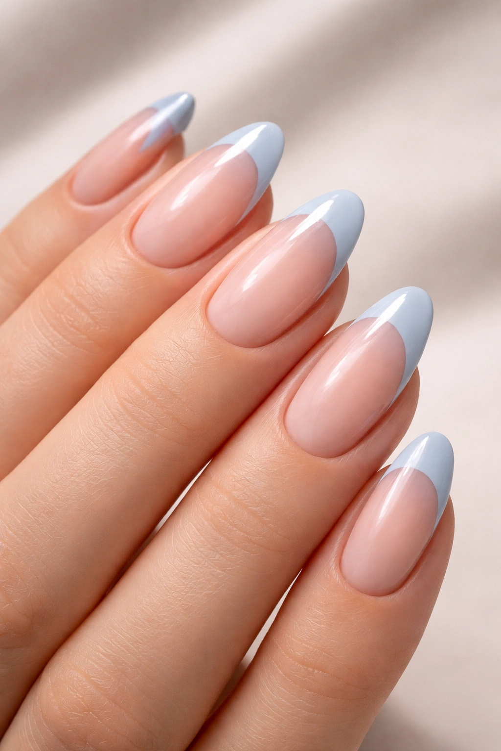 Close-up of powder blue French tips on a subtle natural base