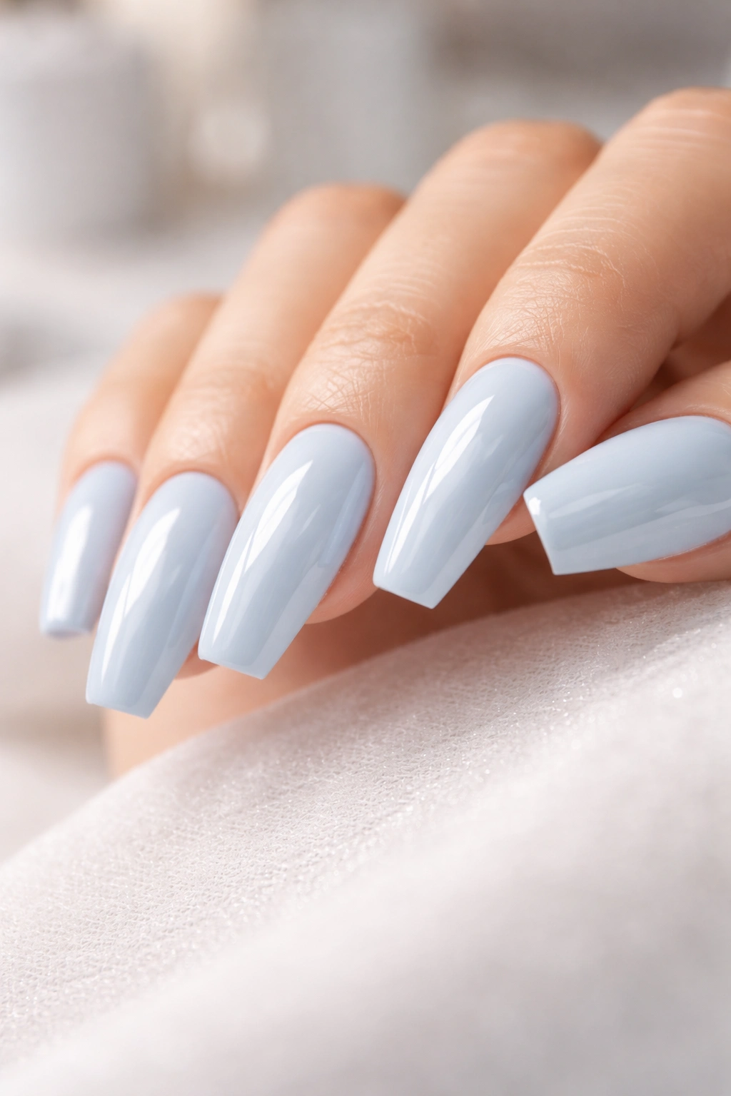Powder blue ballerina nails with milky glossy finish on medium-length tips.