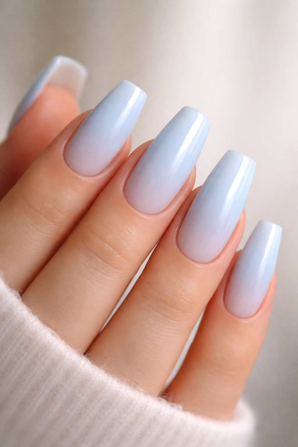 Close-up of powder blue coffin nails with ombré to white tips
