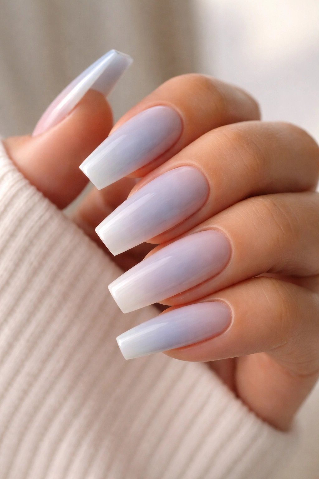 Powder blue coffin nails fading to nude tips in a soft ombré