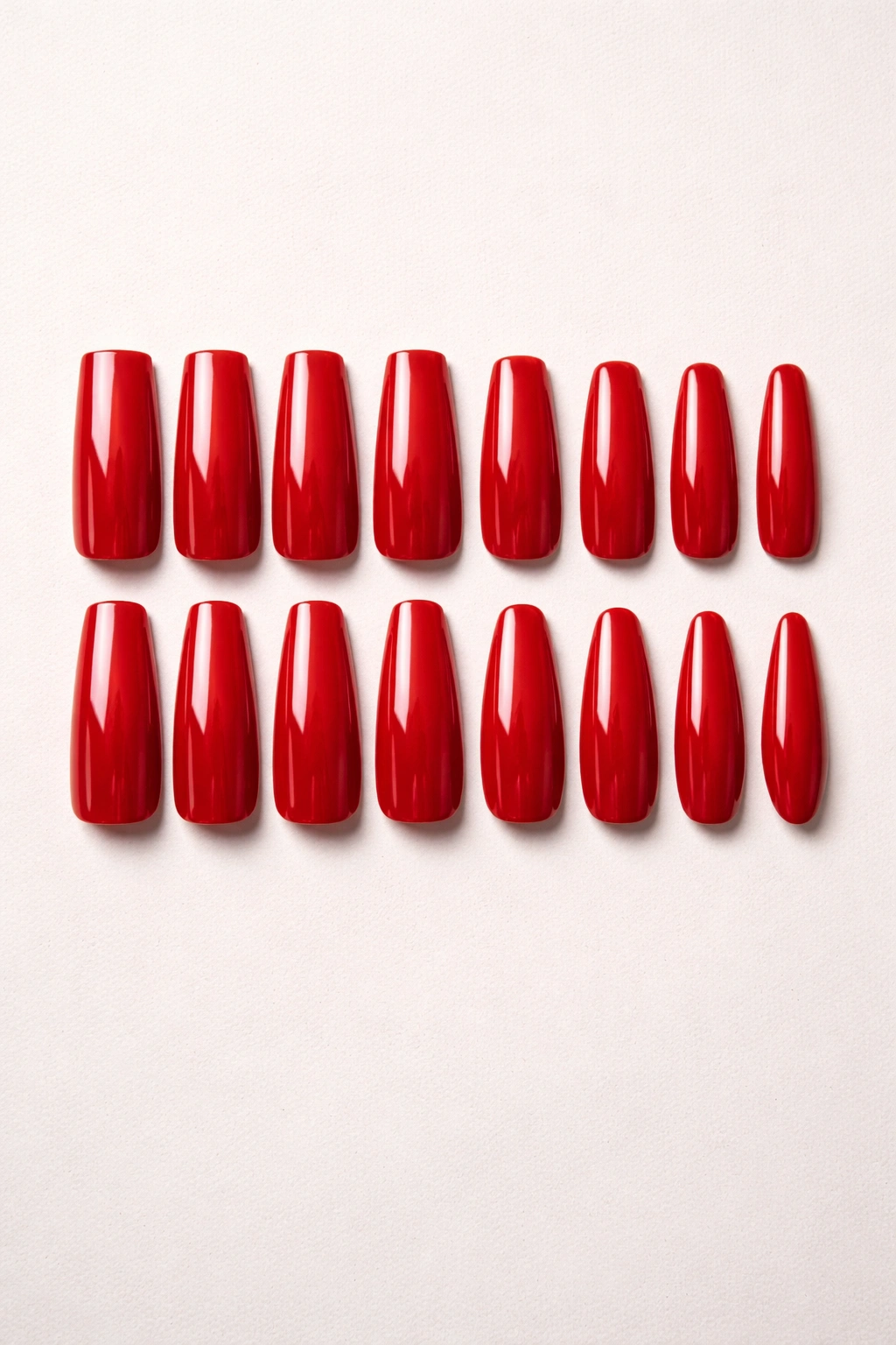Row of red press-on nail tips in various shapes