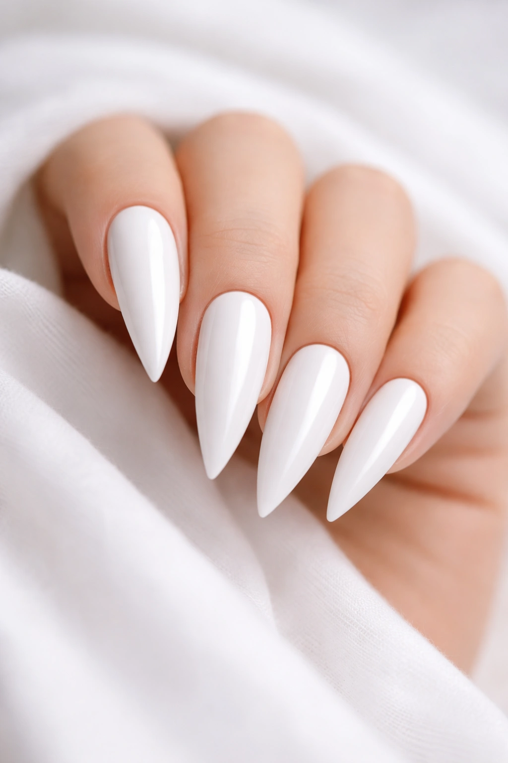 Close-up of pure white stiletto nails with no embellishments