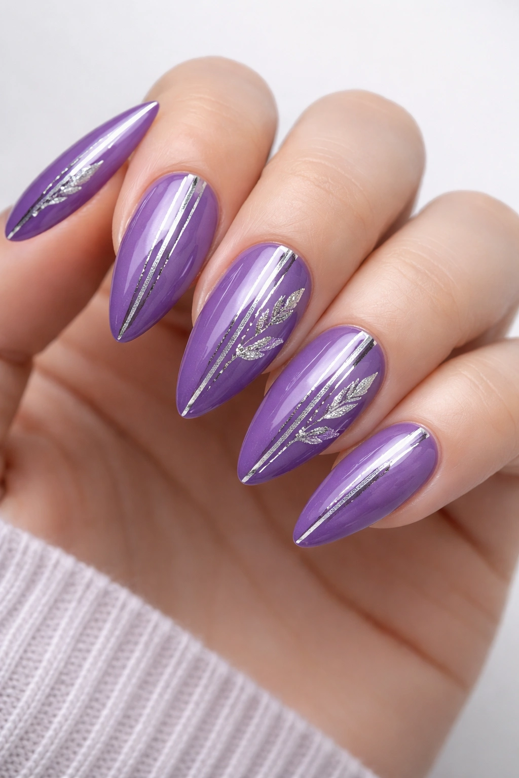 Almond-shaped purple nails with silver stripe and leaf details
