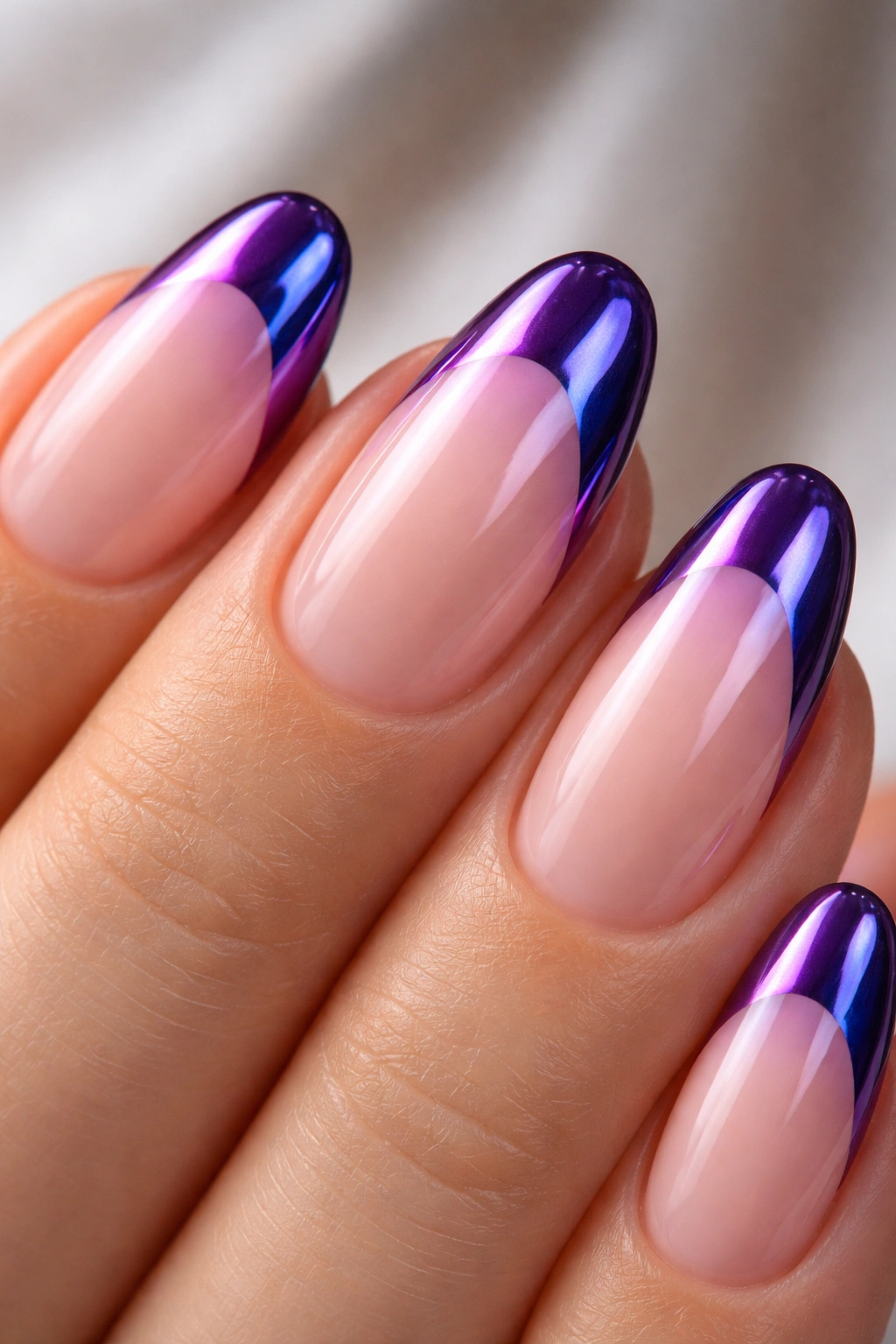 Close-up of a short almond nail with shiny purple chrome tip