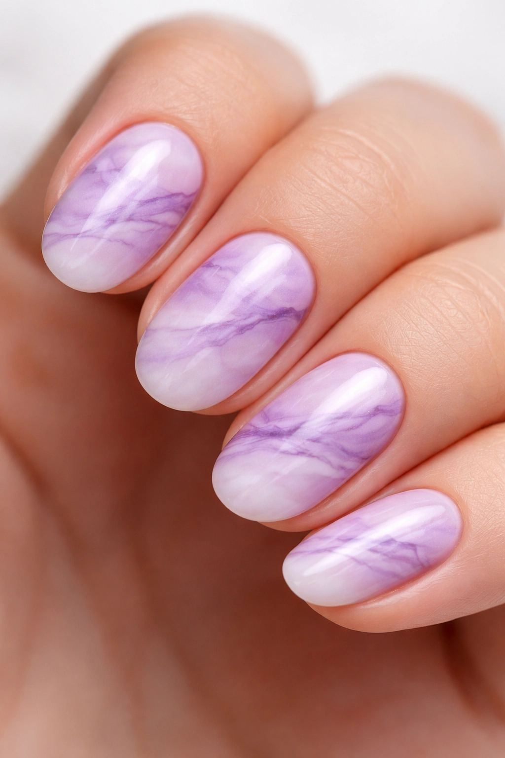 Short oval nail with purple marble veining on lilac and white