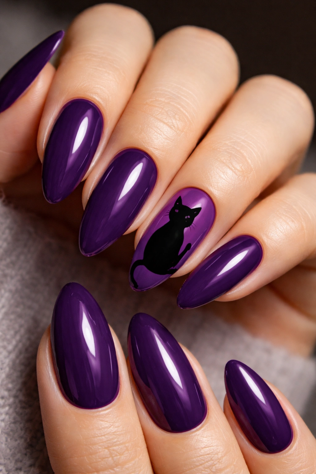 Almond nails with purple background and black cat silhouette on accent nails