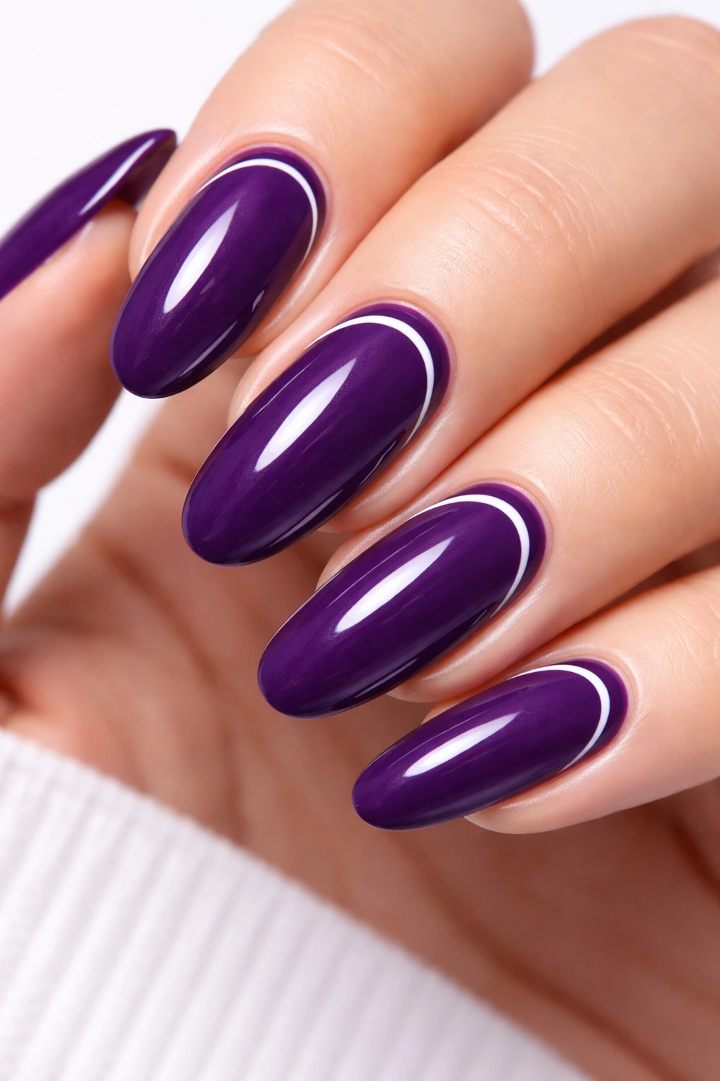 Deep purple oval nails with white crescent moons on long nails