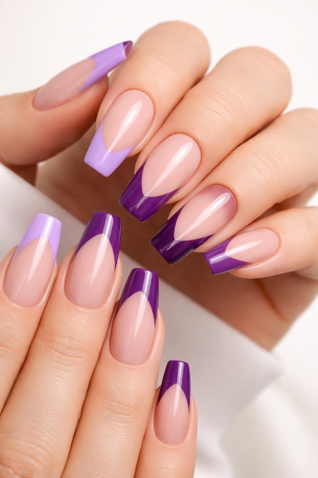 Close-up of purple French tips on nude base with lavender to deep purple tips