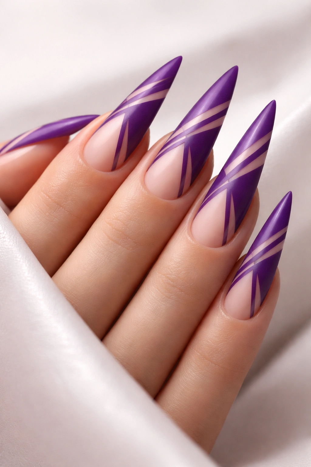 Close-up of purple stiletto nails with negative-space geometric patterns