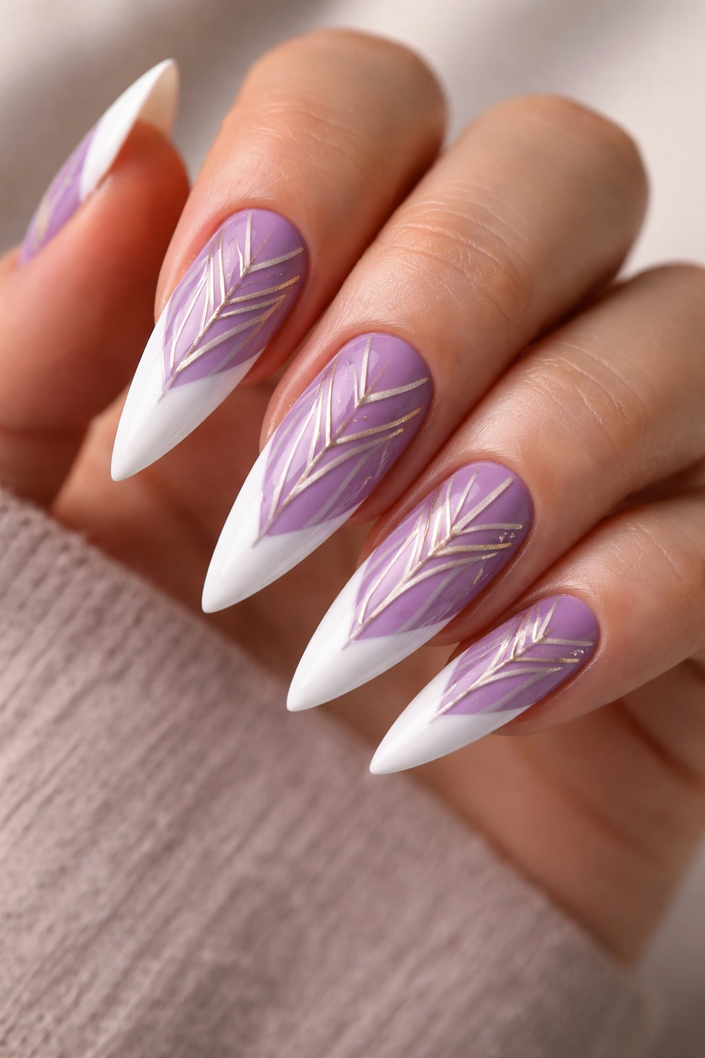 Close-up of purple stiletto nails with white tips and geometric nail art patterns on the nail beds