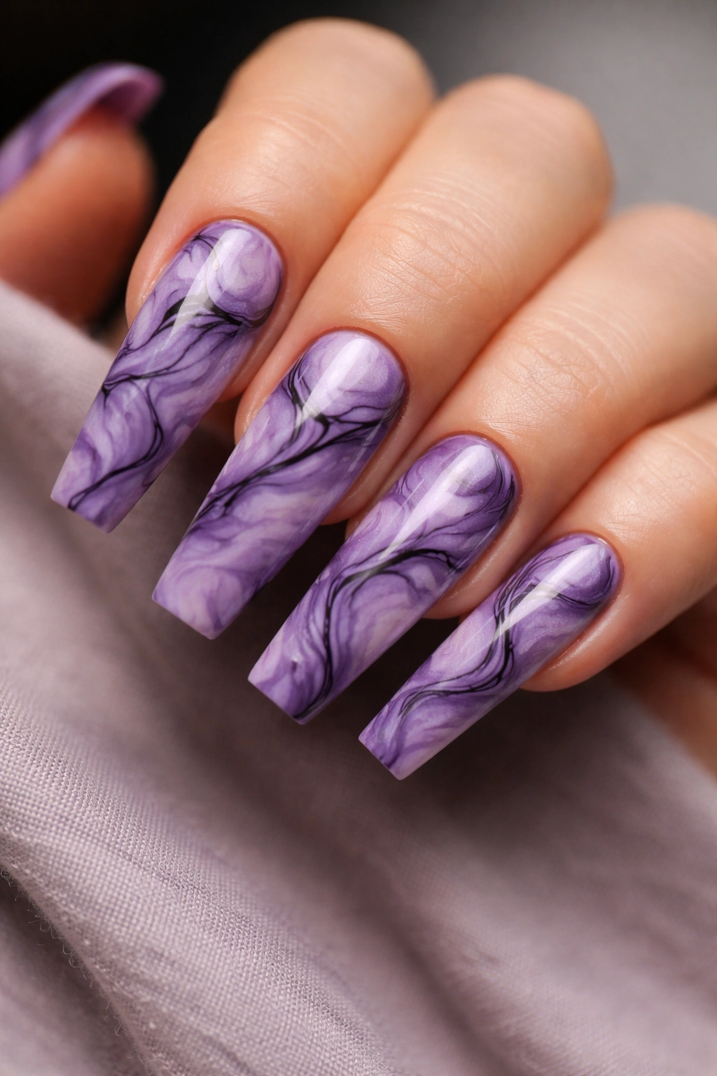 Close-up of coffin nails with purple marble and black swirls