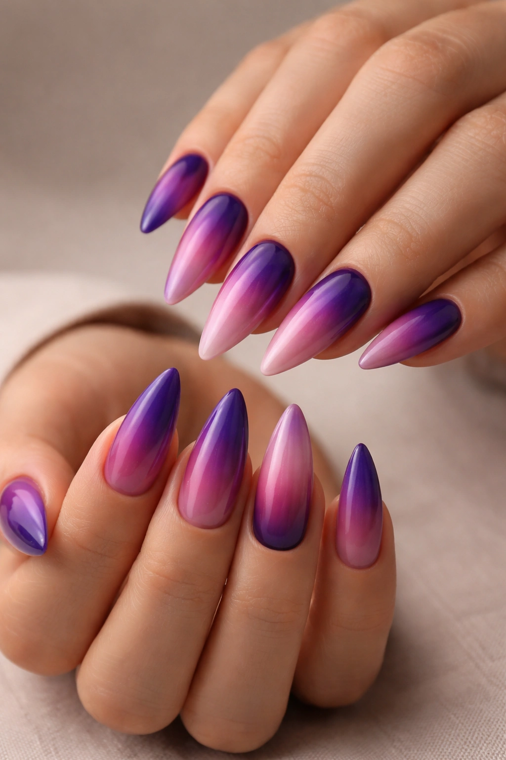 Close-up of medium stiletto nails with purple to pink ombre