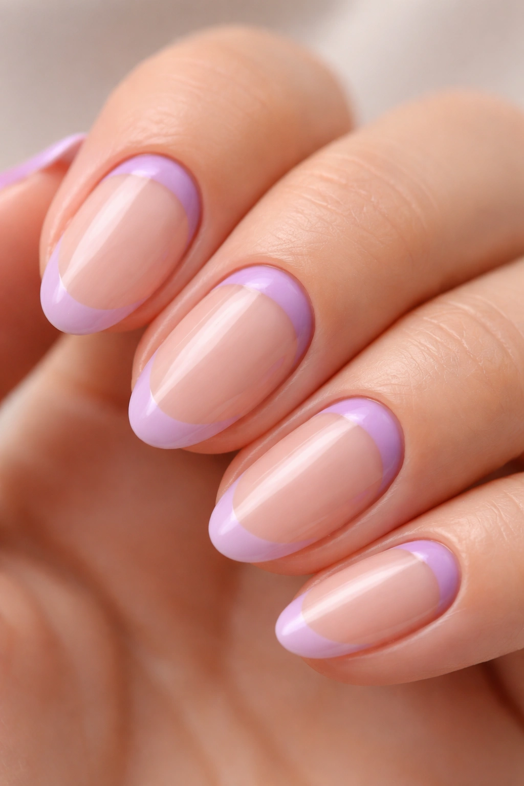 Close-up of short almond nail with purple reverse French crescent at the base along the cuticle