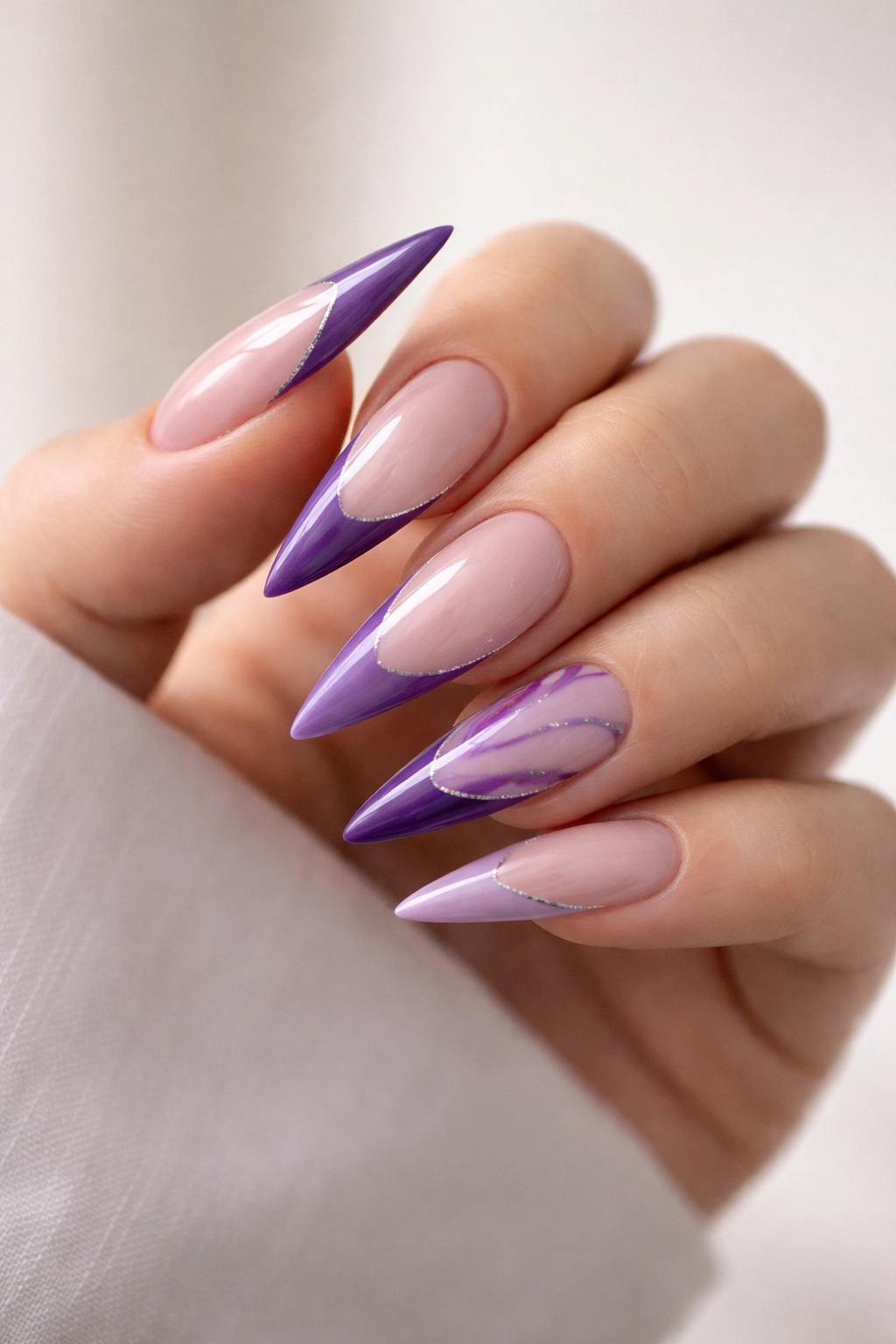 Hand with finished purple stiletto nails on a neutral background