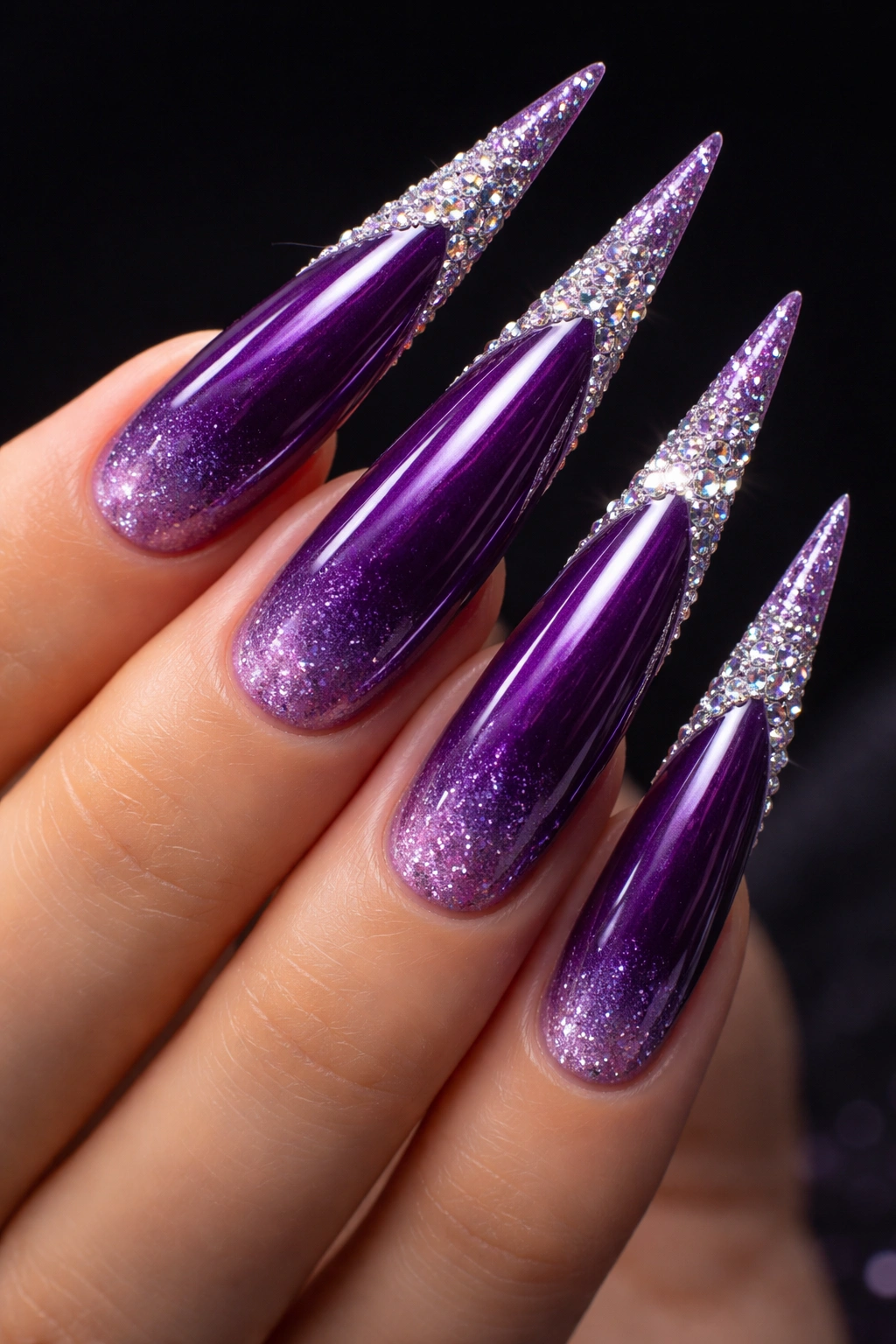 Stiletto nails with purple polish and rhinestone tips