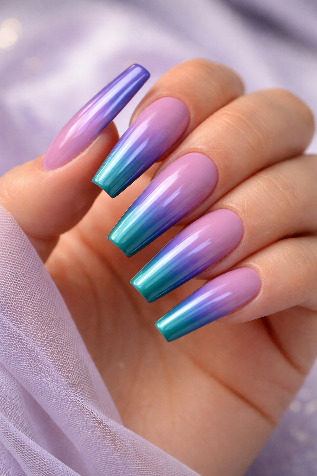 Close-up of coffin nails with purple to teal ombré gradient.