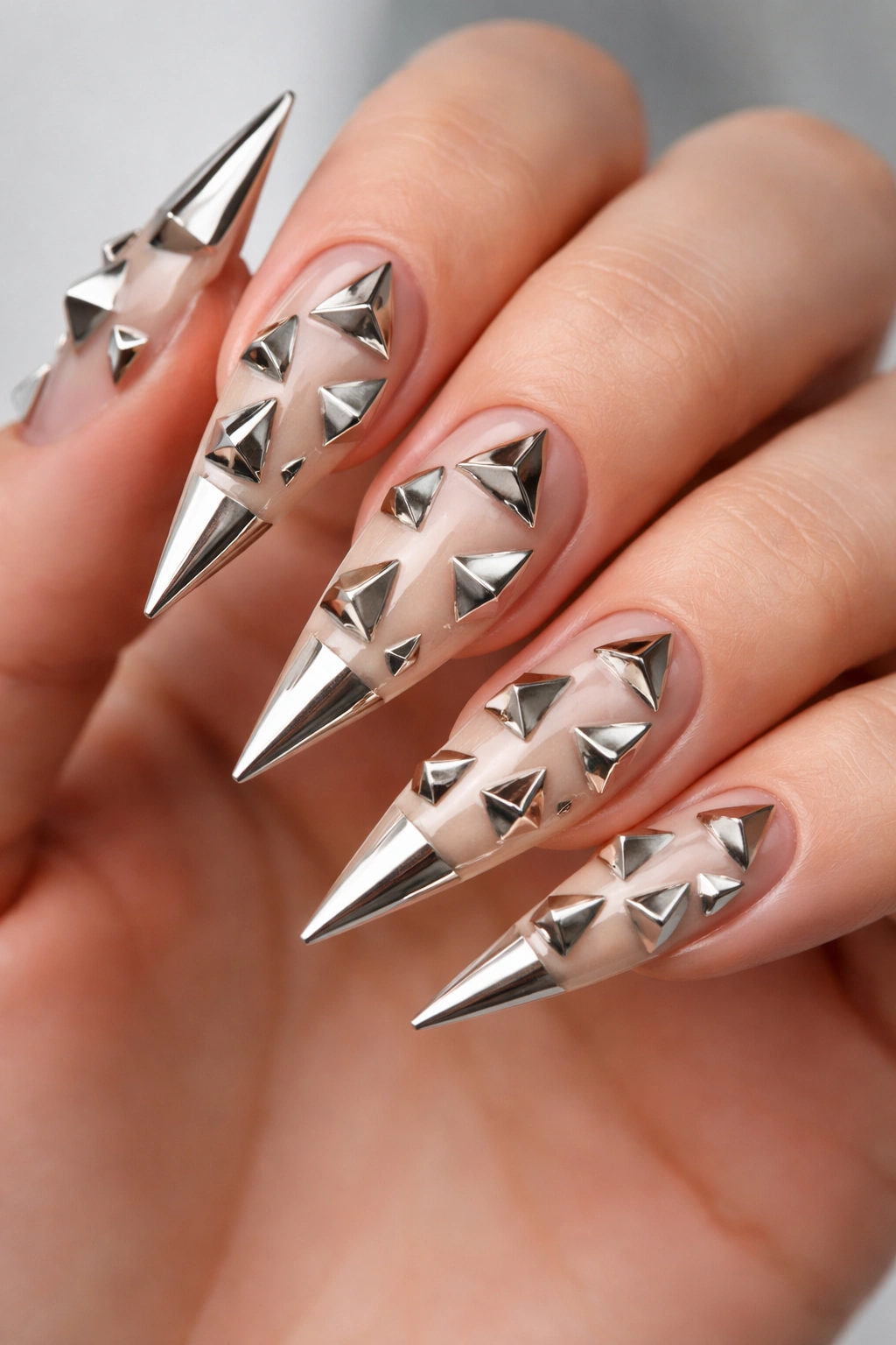 Close-up of stiletto nails with metallic pyramids protruding