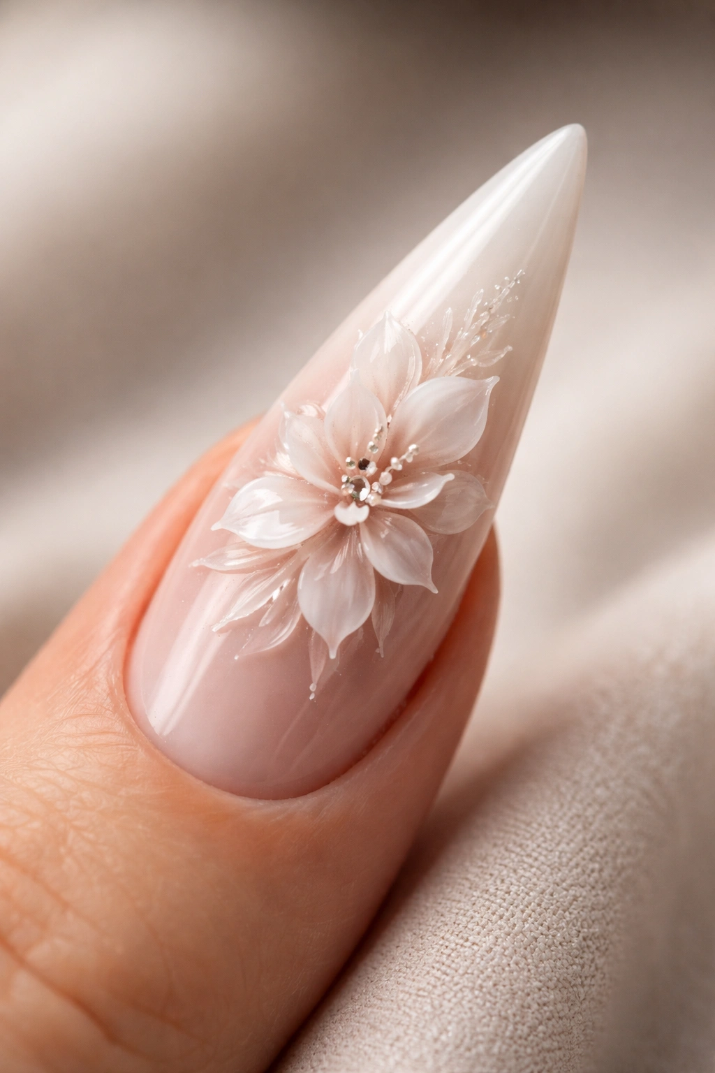 Close-up of a single stiletto nail with raised floral sculpture