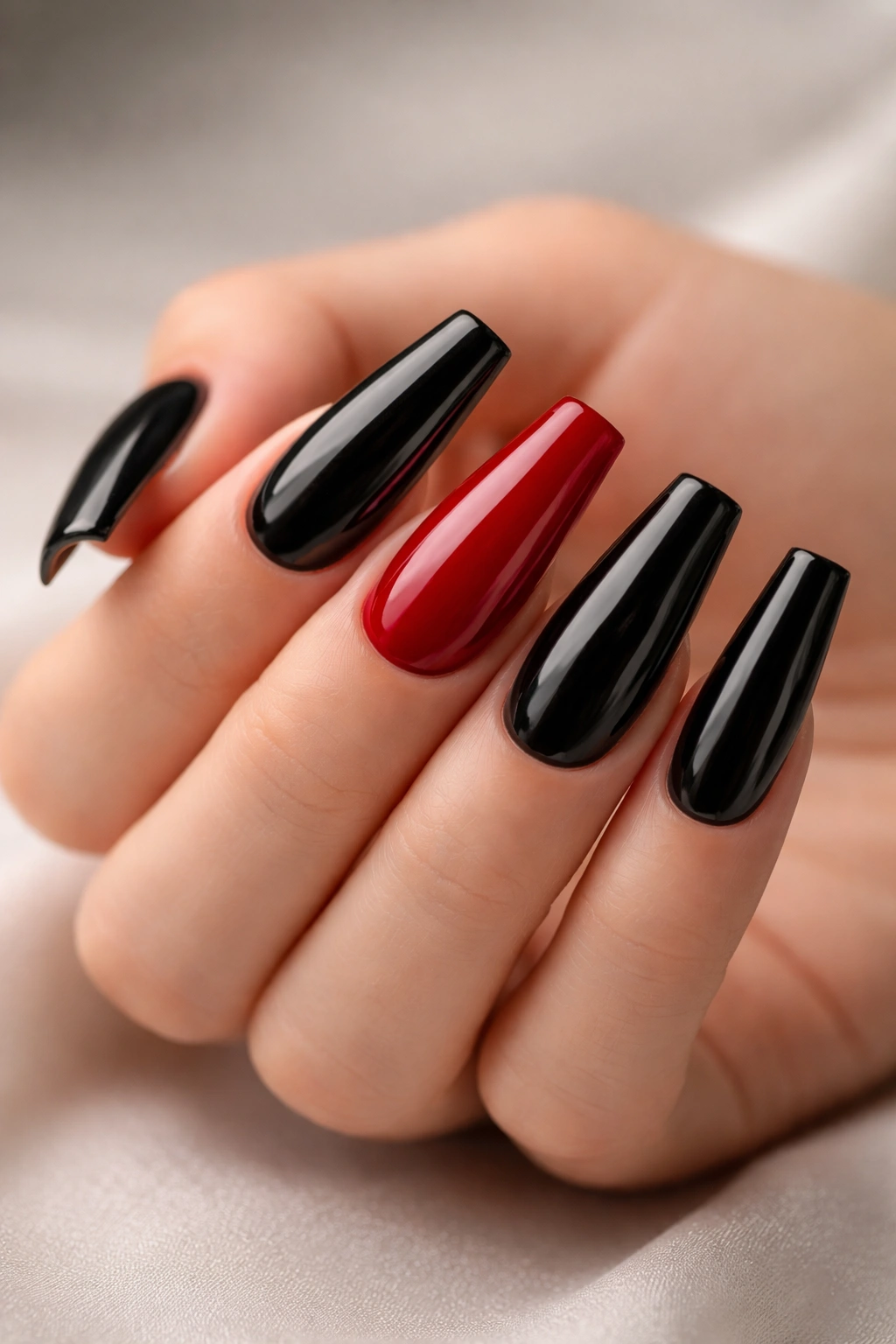 Close-up of red and black ballerina nails with flat tips in studio lighting