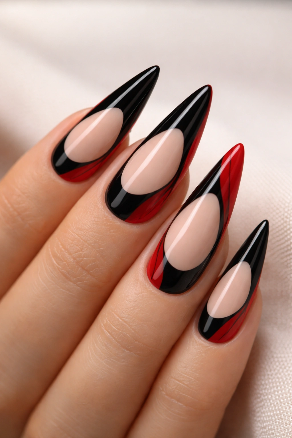 Close-up of red and black negative-space stiletto nails on nude base