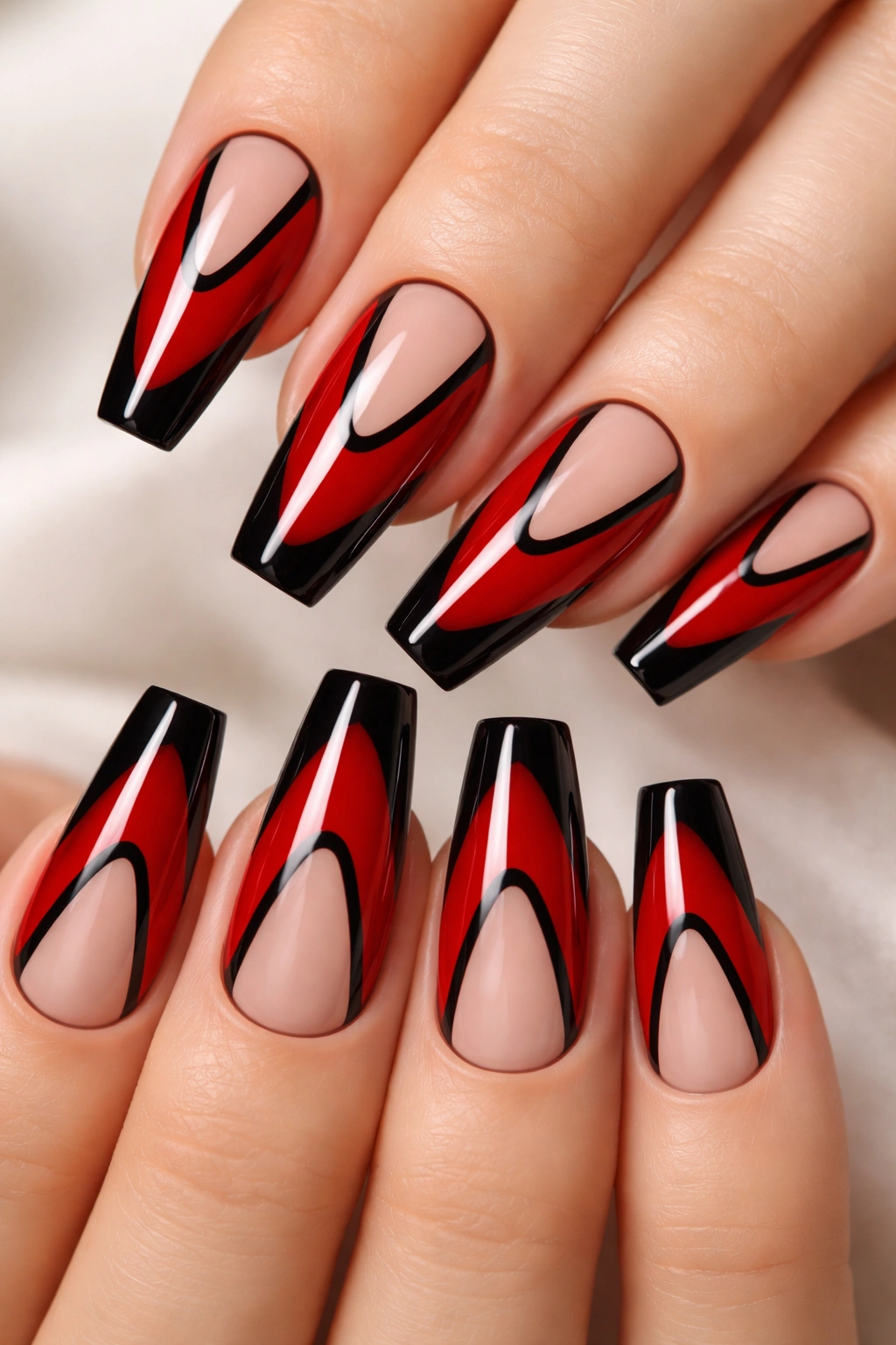 Close-up of glossy red coffin nails with black negative-space outlines, medium length