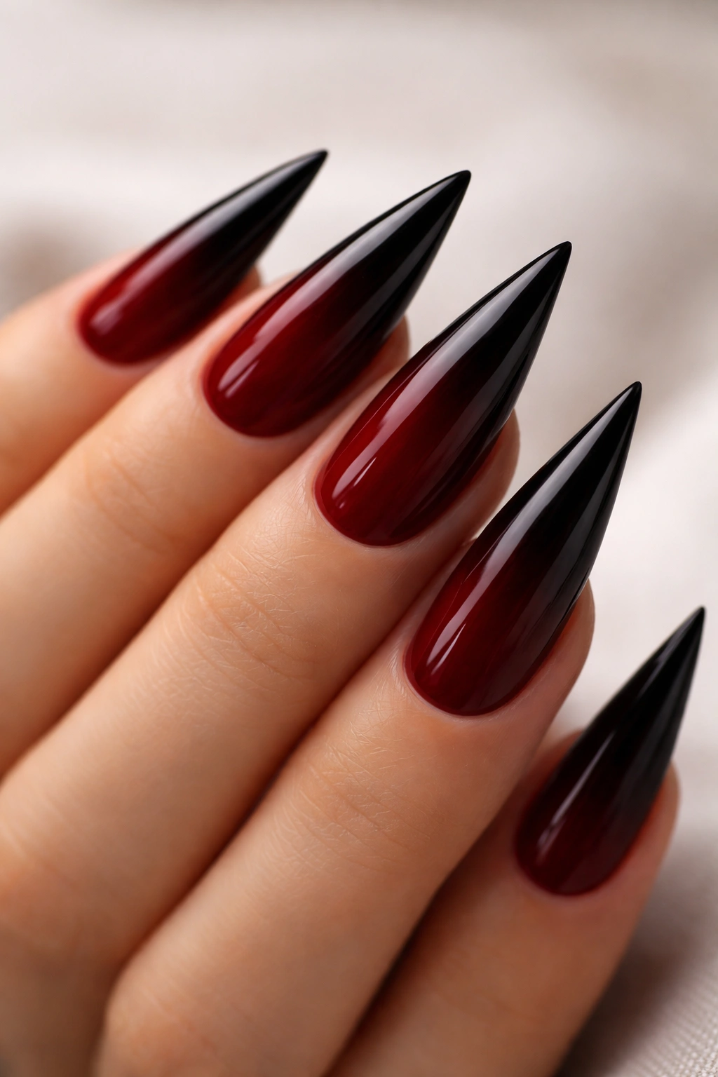 Dark red to black ombre stiletto nails.