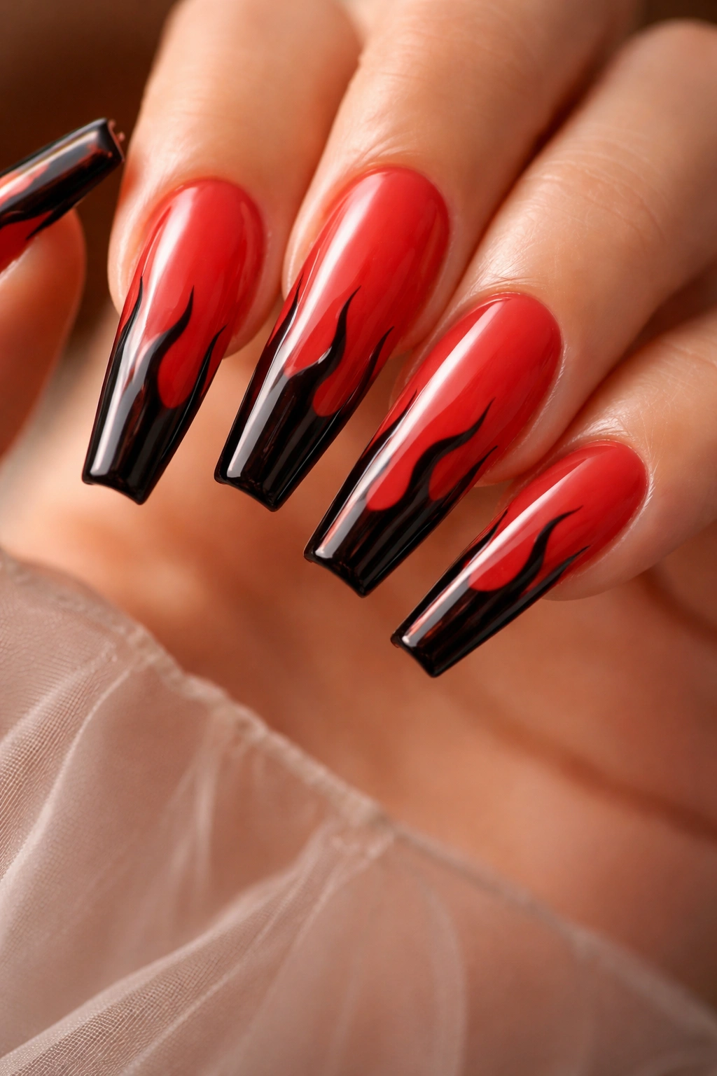 Translucent red jelly nails with black flame tips on long ballerina nails