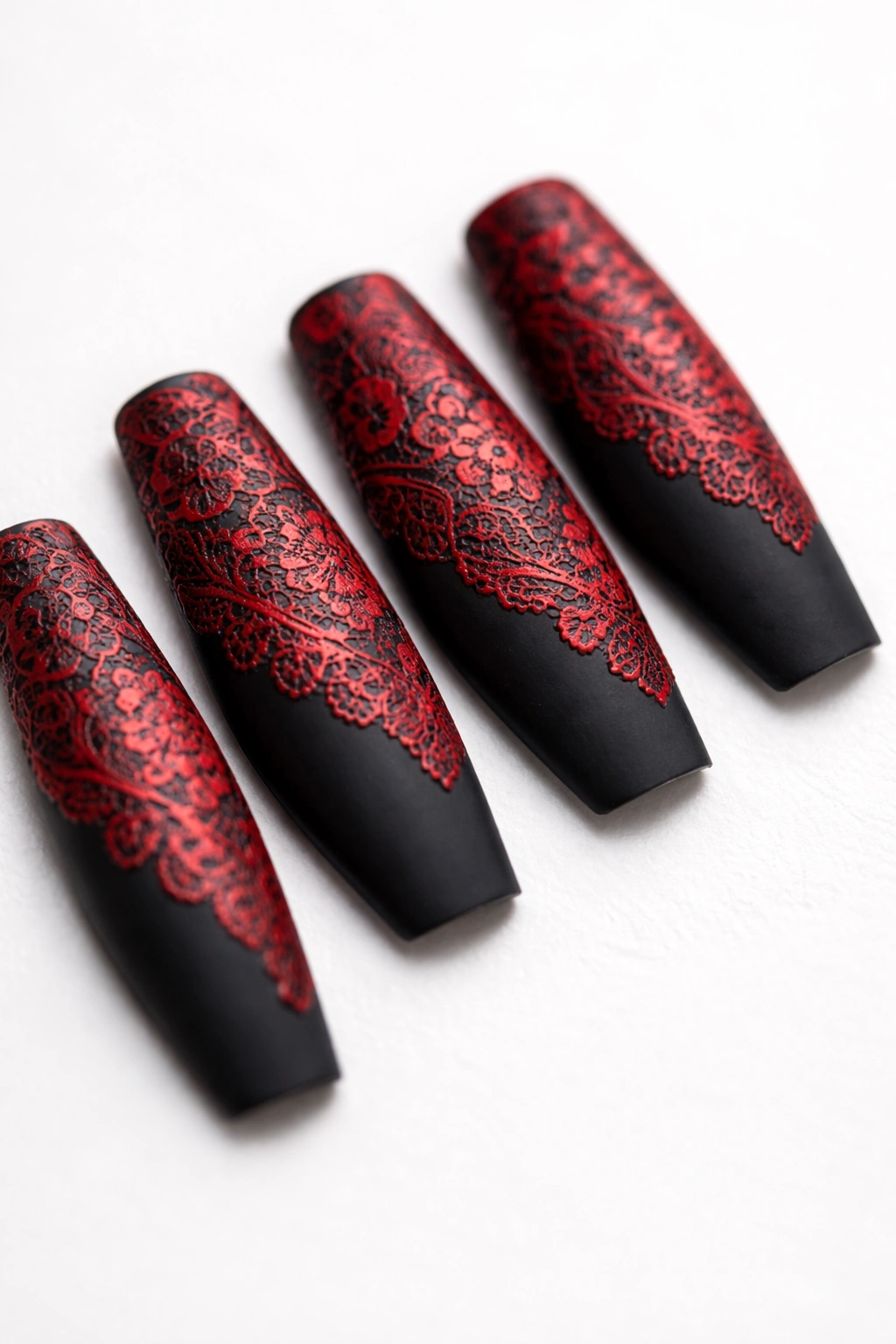 Macro close-up of coffin nails with black base and red lace pattern