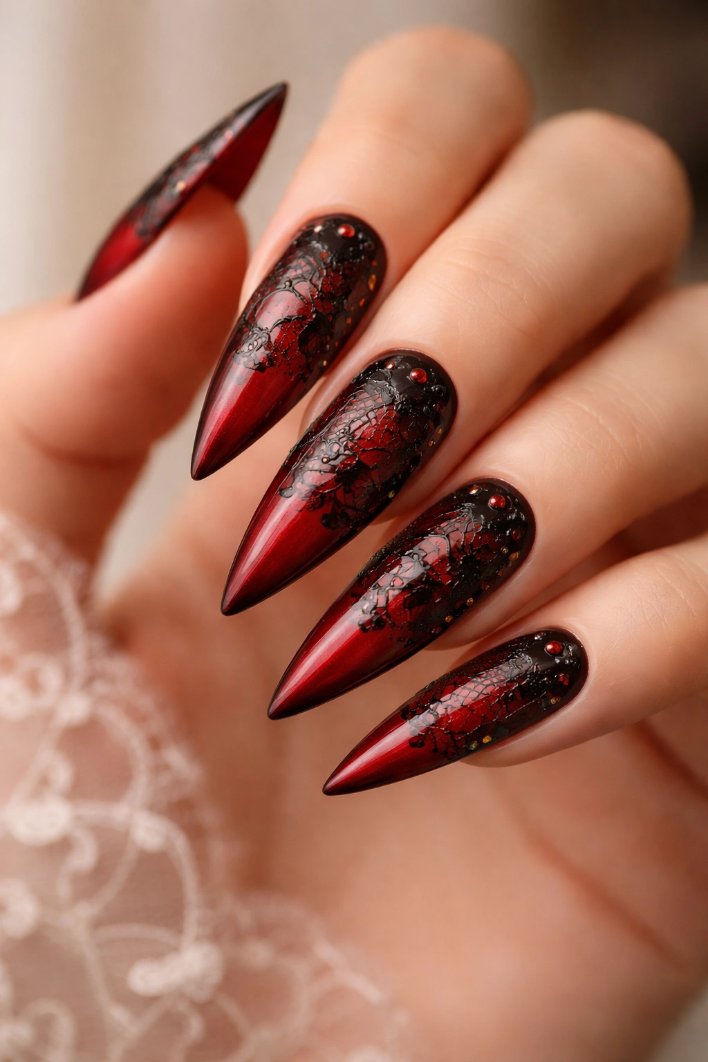 Red nails with delicate black lace pattern and negative space accents.