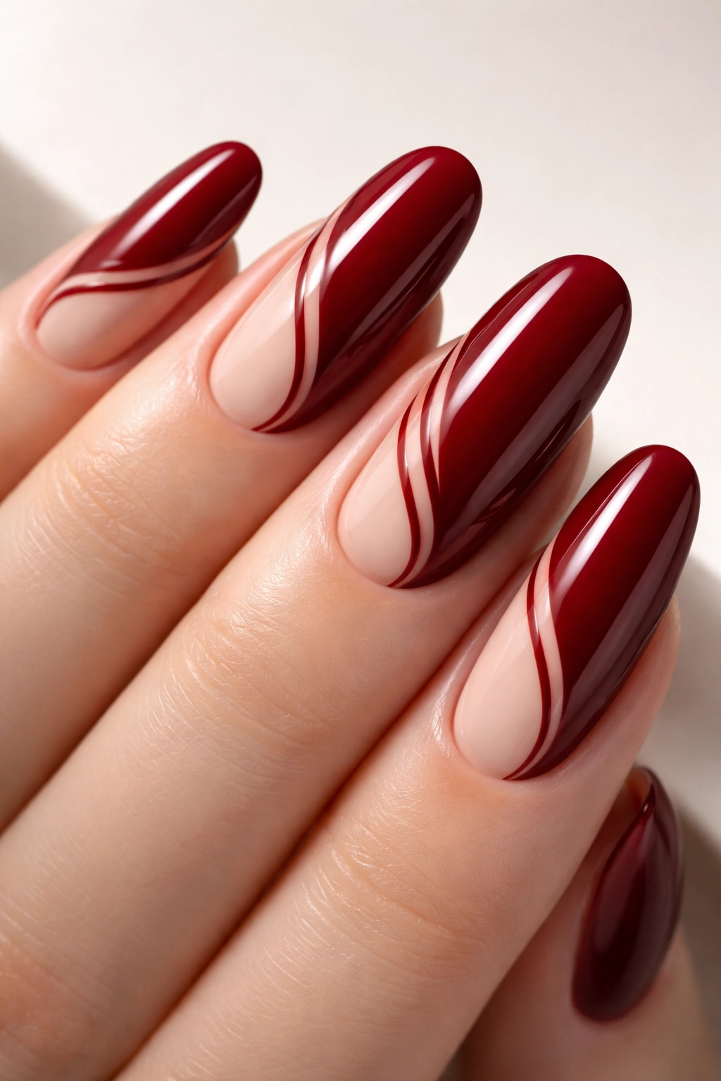 Close-up of long round nails with red polish and negative-space lines