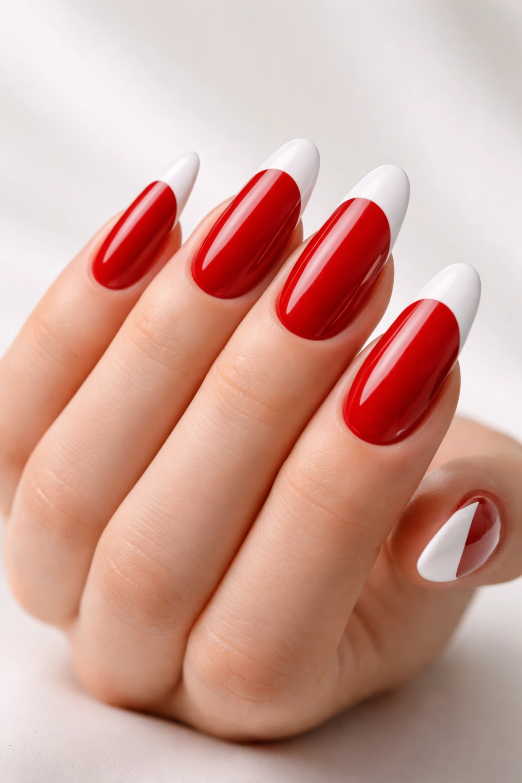 Long round nails with a red base and white tips, bold and polished.