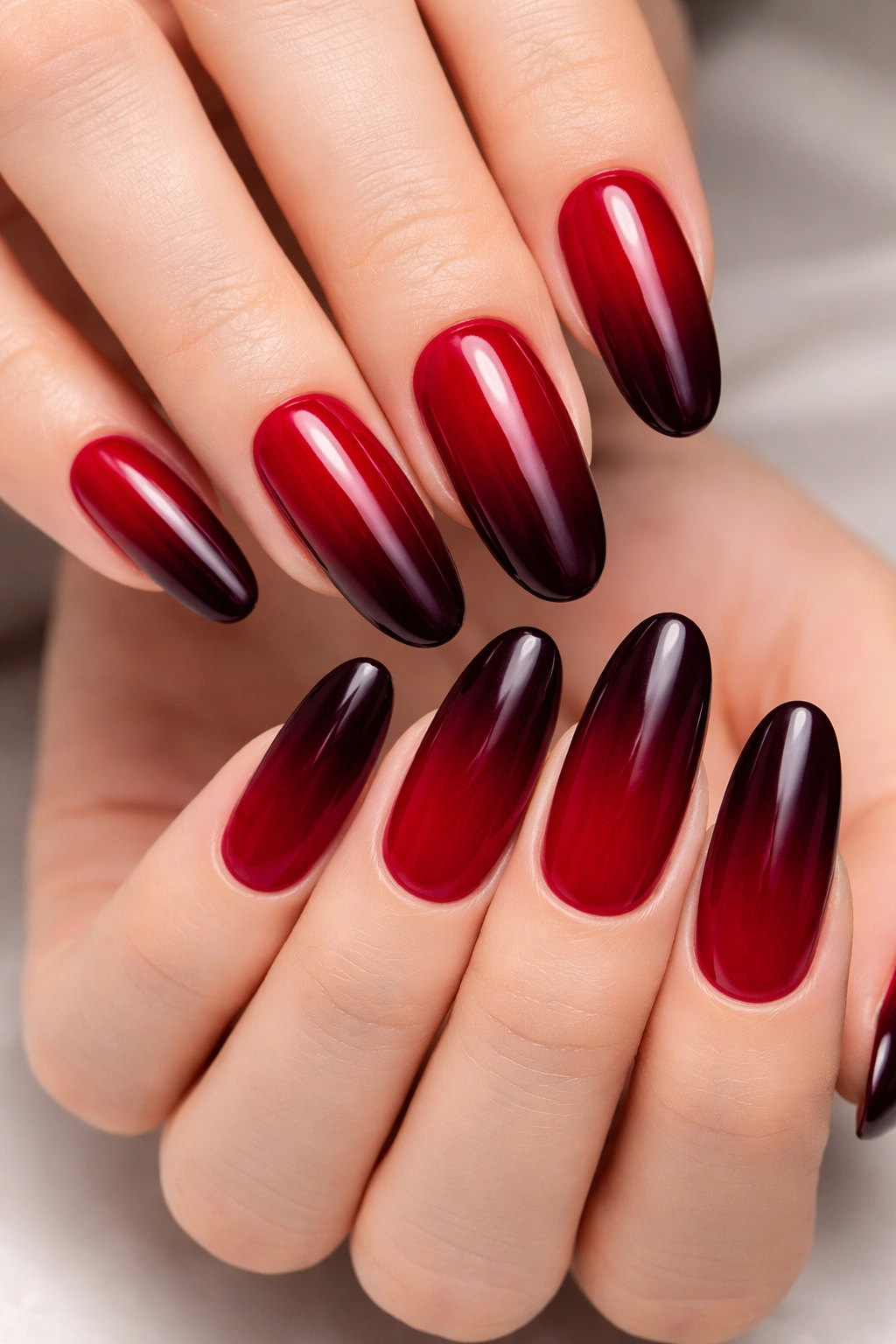Nails with deep red to burgundy ombre on long rounded nails