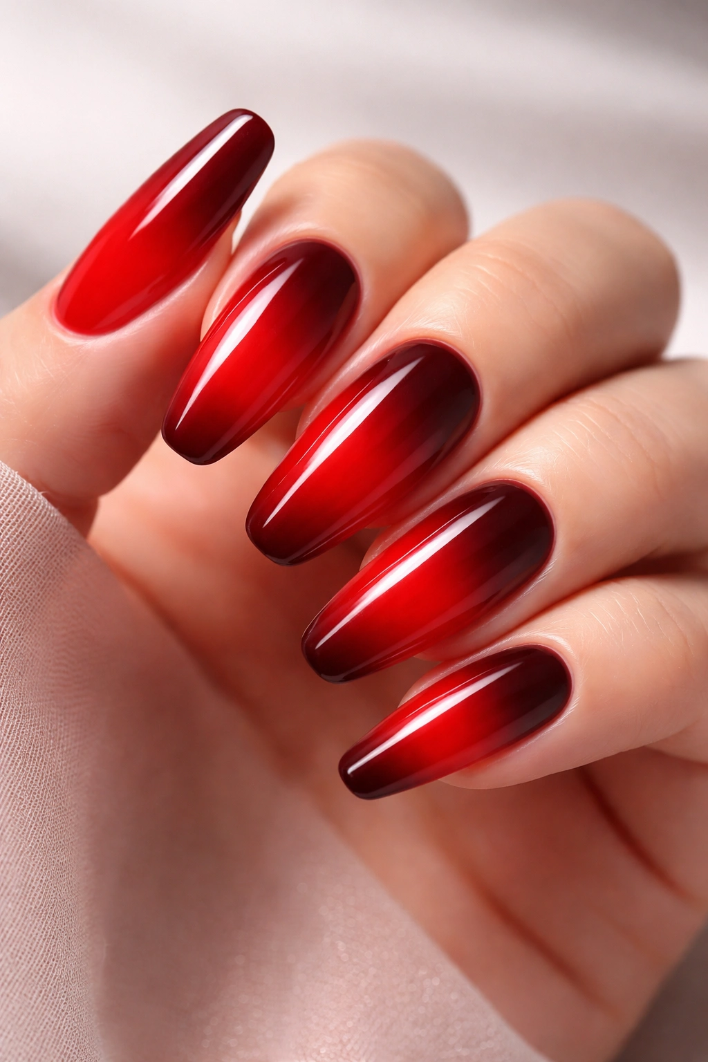 Close-up of red ombre nails with a cherry to burgundy gradient