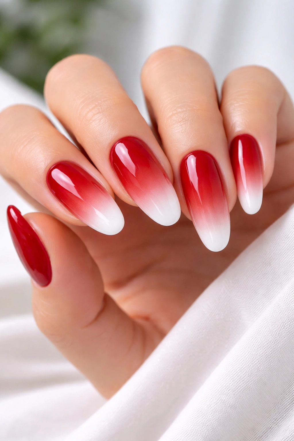 Red ombre nails with red to nude gradient reverse French on long ovals