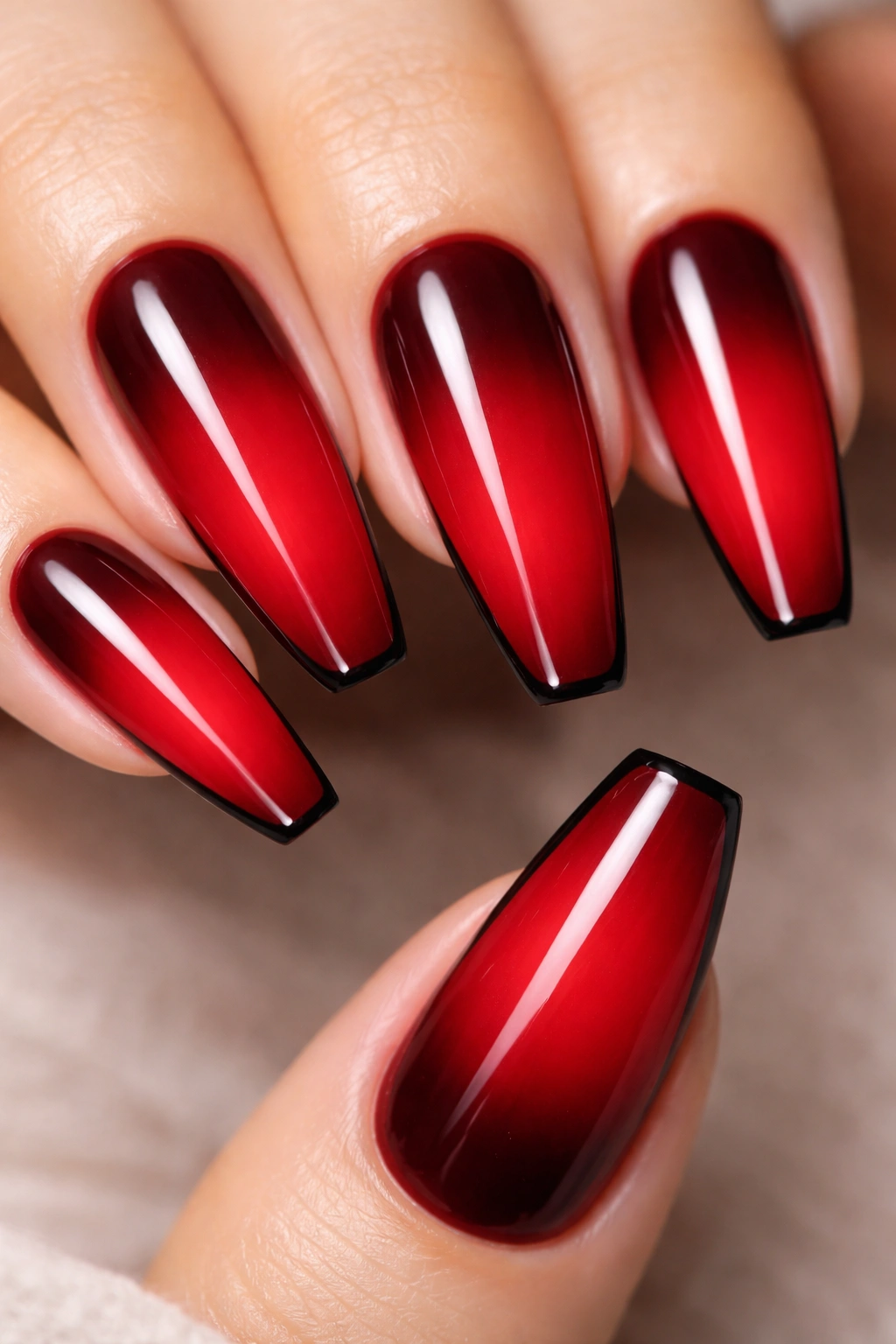 Coffin nails with reverse red ombre from dark cuticle to bright tip and a thin black edge